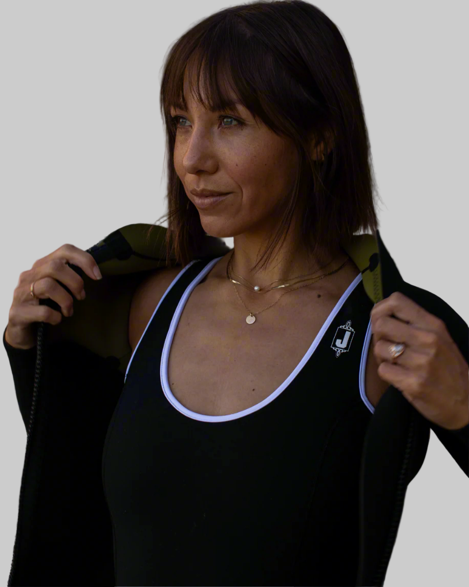 Woman wearing a black top with white trim against a plain background