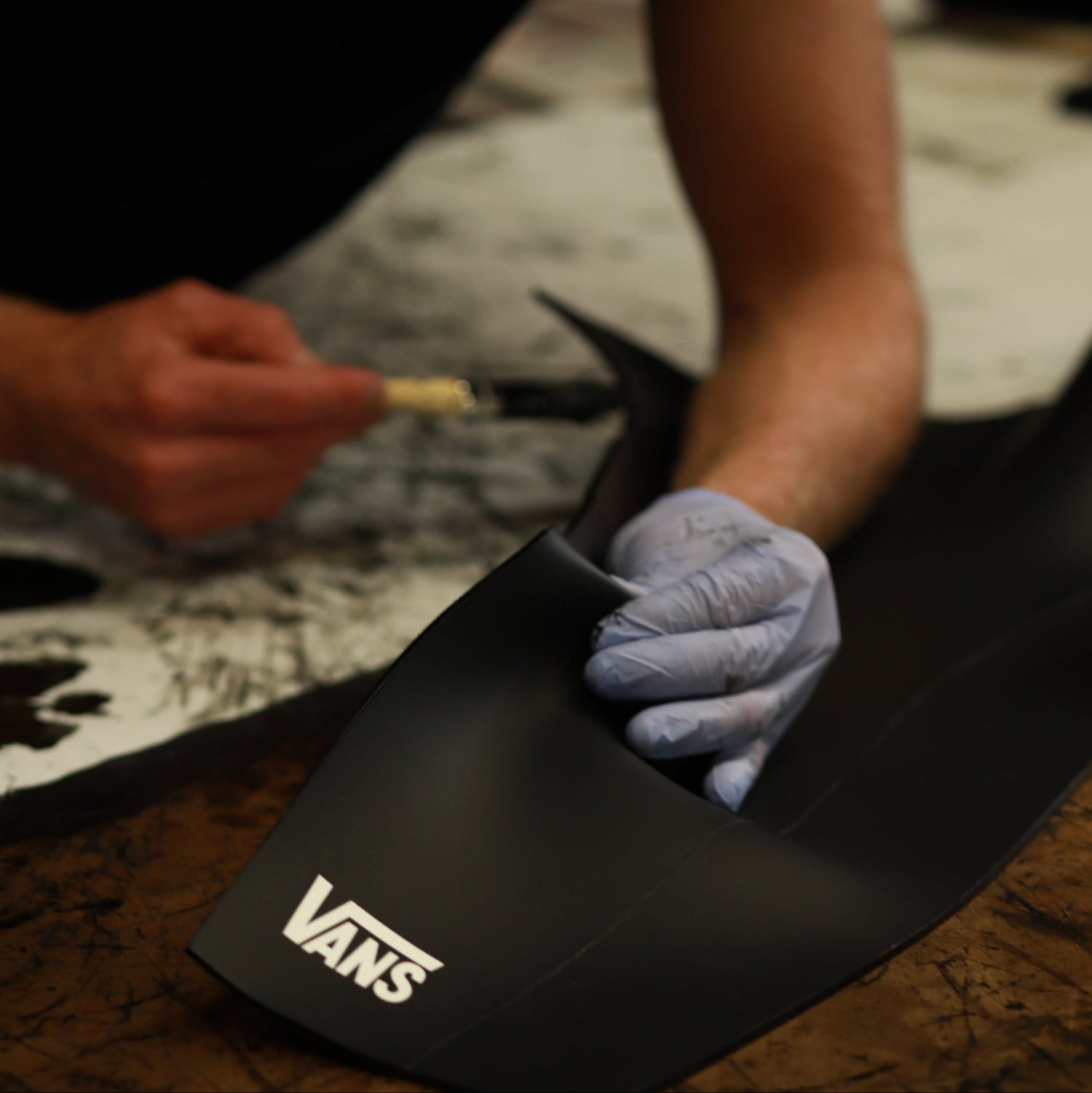 Jonesea gluing a Custom VANS smoothie wetsuit.